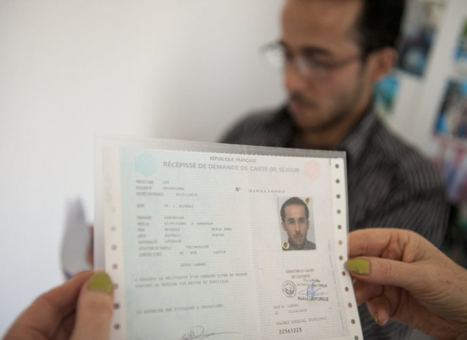 Dans un bureau, un récépissé de demande de titre de séjour enregistrée est remise au demandeur 