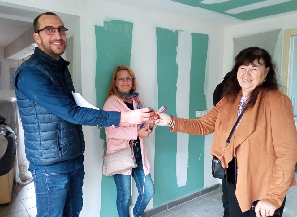 La remise des clefs est un moment important pour les familles. Ici, les 3 acteurs du programme : la famille, la bénévole référente et le coordinateur technique de REH